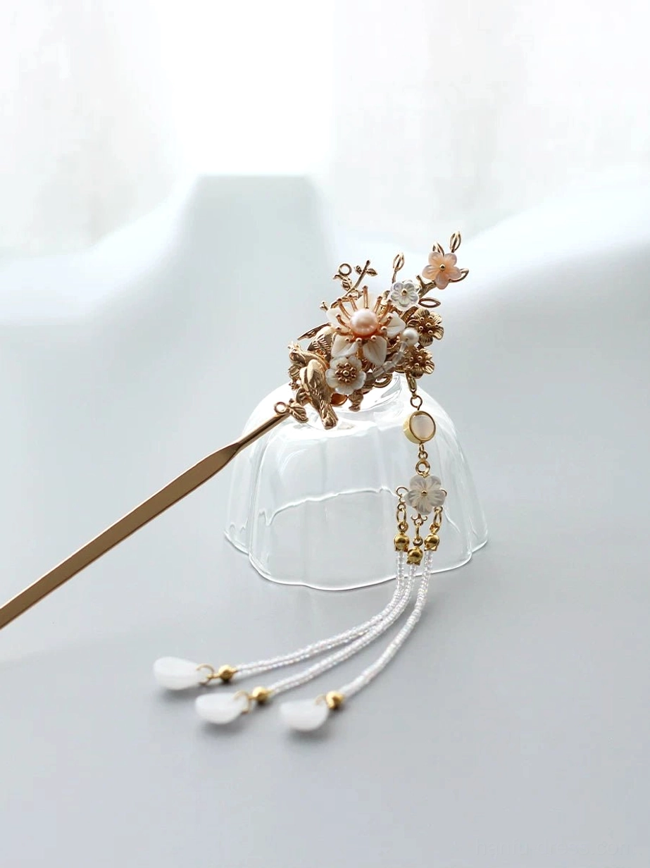 Elegant Chinese hair stick showing flower and bird decoration, pink floral details, long white tassel, beads, and gold-capped hanging pendants