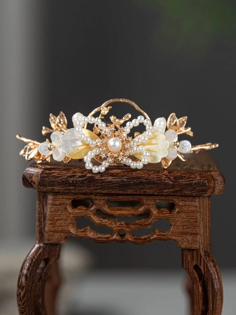Elegant Chinese Hanfu hair crown with gold-toned leaf and floral framework white shell-inspired flowers and clustered faux pearls shown from a three-quarter view