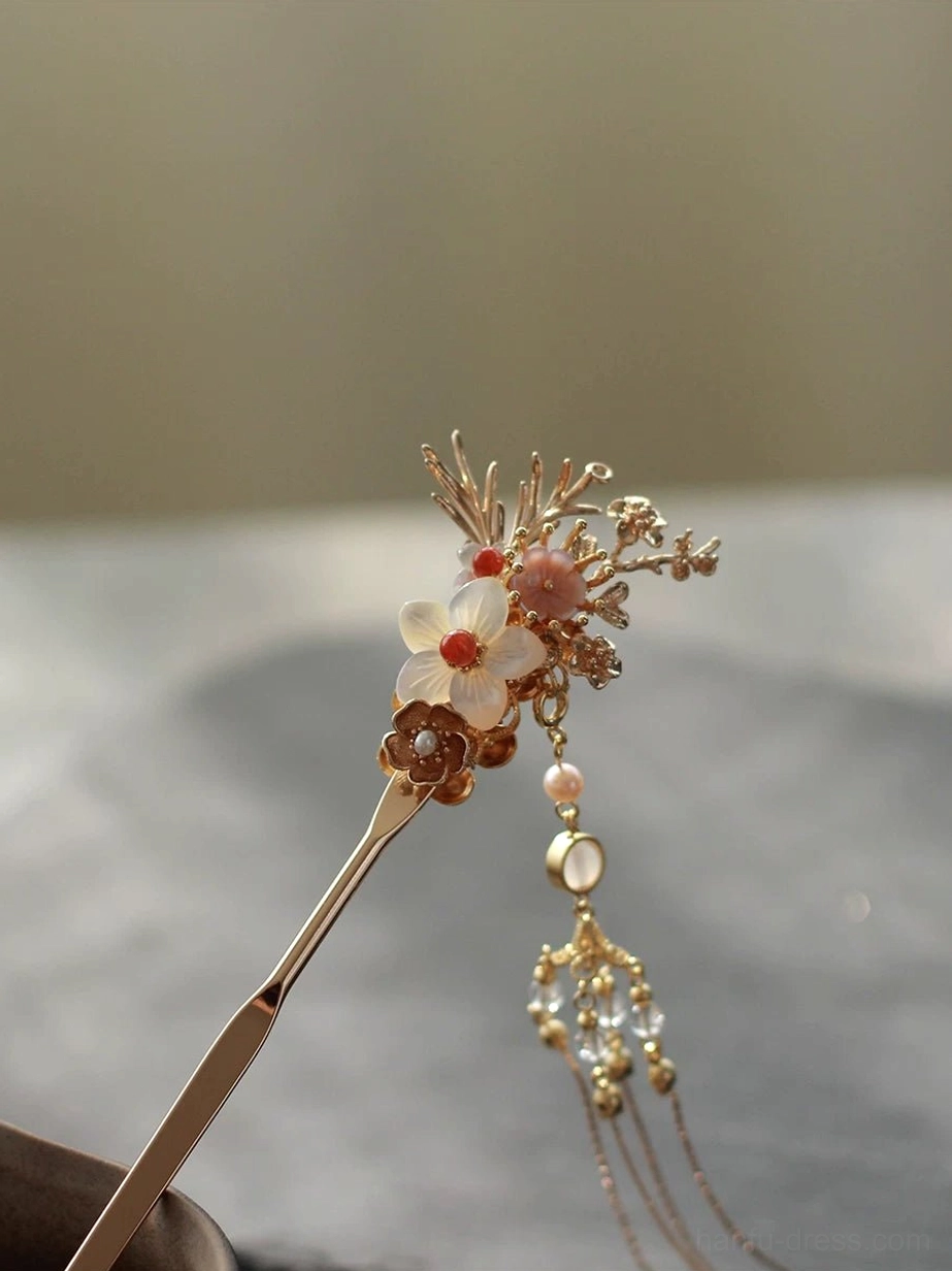 Elegant traditional Chinese hair accessory with warm gold floral metalwork, matching flower motifs, round beads, dangling crystals, and a graceful tassel