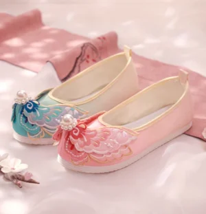 Embroidered Chinese Hanfu shoes showing pink and cyan-pink color variations with pearl toe decorations, tassel details, golden edging, and traditional cloth construction