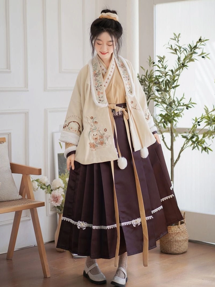 Front view of an embroidered Modern Hanfu three-piece set with beige fluffy cardigan, burgundy mamian skirt, cross-collar top, floral embroidery, lace trim, and pom-pom details