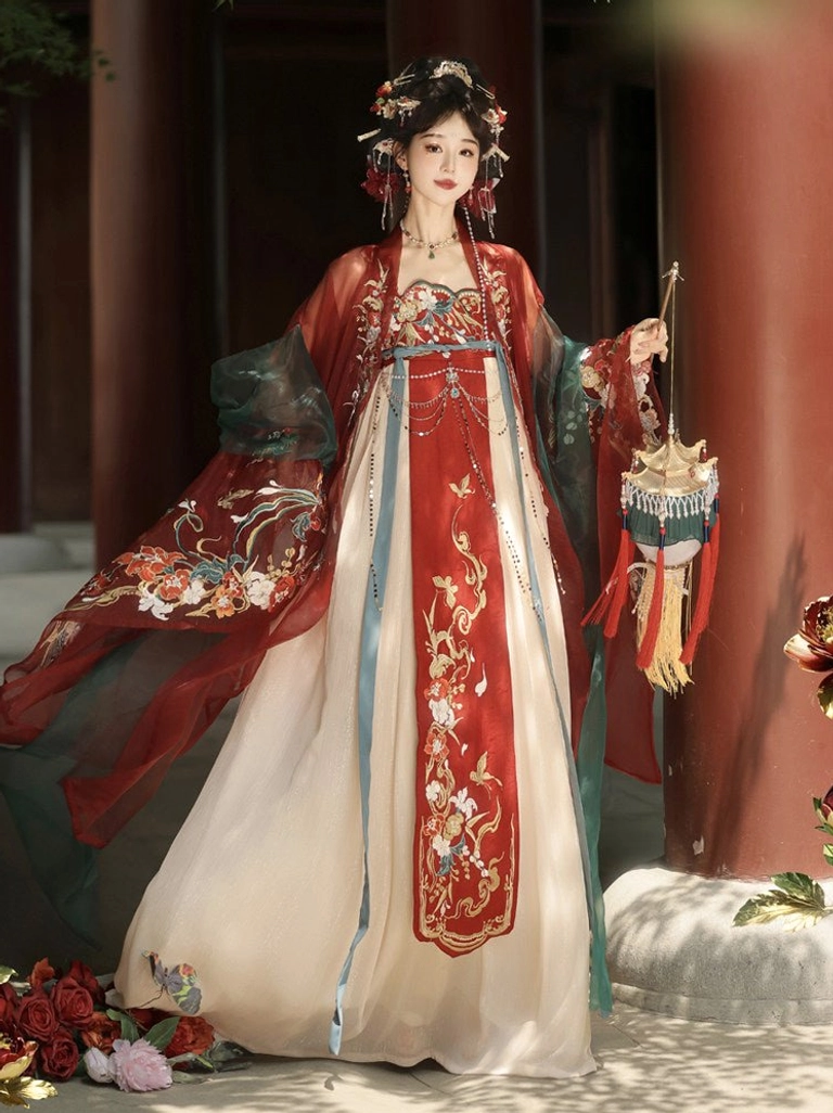 Front view of an embroidered Tang Dynasty Qixiong Ruqun Hanfu costume beside a red courtyard pillar, featuring an auspicious red front panel, sheer cape, and traditional Chinese lantern