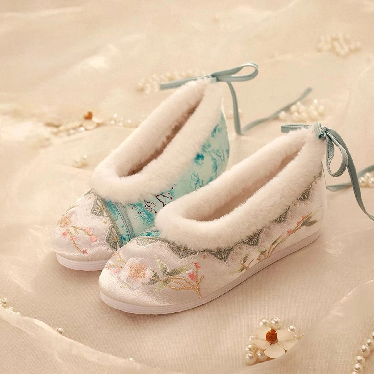 Embroidered traditional Chinese Hanfu shoes for women displayed side by side on beige satin, featuring floral toe embroidery, soft faux fur collars, mint green heel ribbons, and hidden wedge inner heightening soles