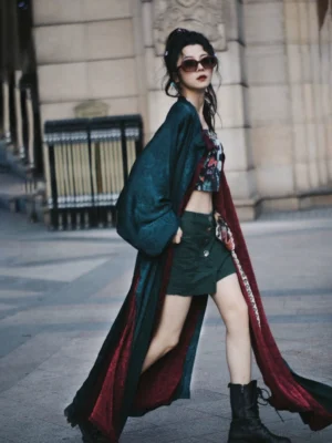 Side walking view of a flowing emerald and scarlet reversible Hanfu robe with long sleeves and modern streetwear styling