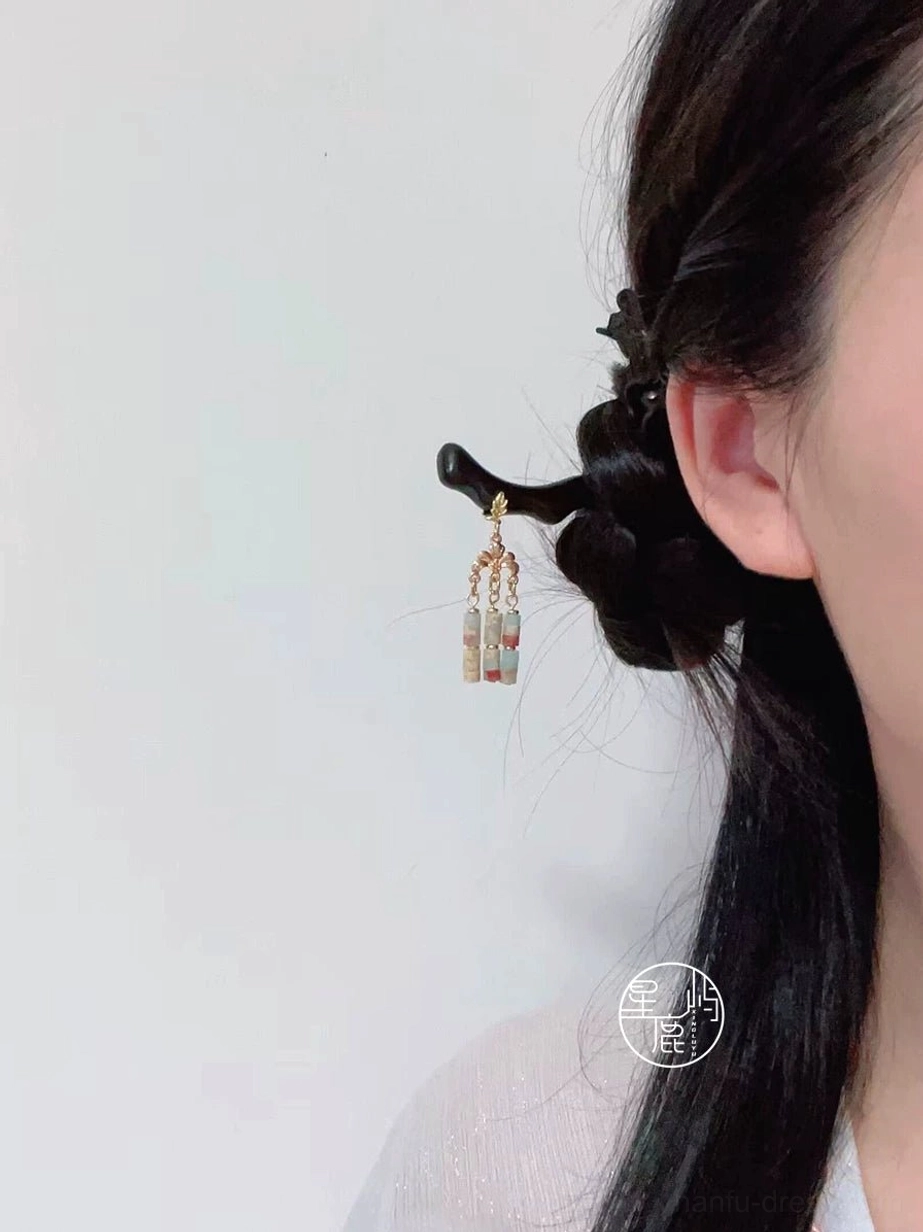 Endless Spring Chinese hair stick worn in a braided Hanfu hairstyle, featuring a curved dark wooden shaft and natural marbled stone tassel beads