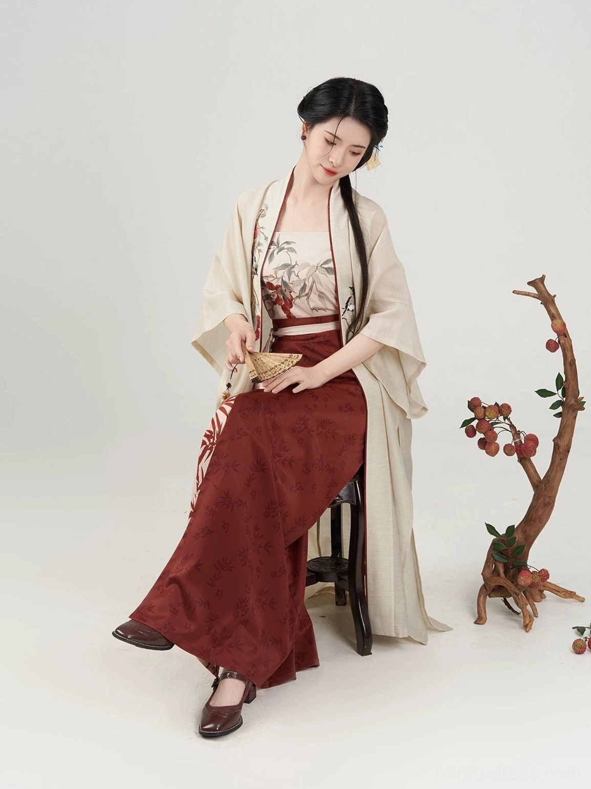 Evening Magpie Song Dynasty Hanfu seated profile showing the floor-length beige overcoat and flowing dark red wrap skirt