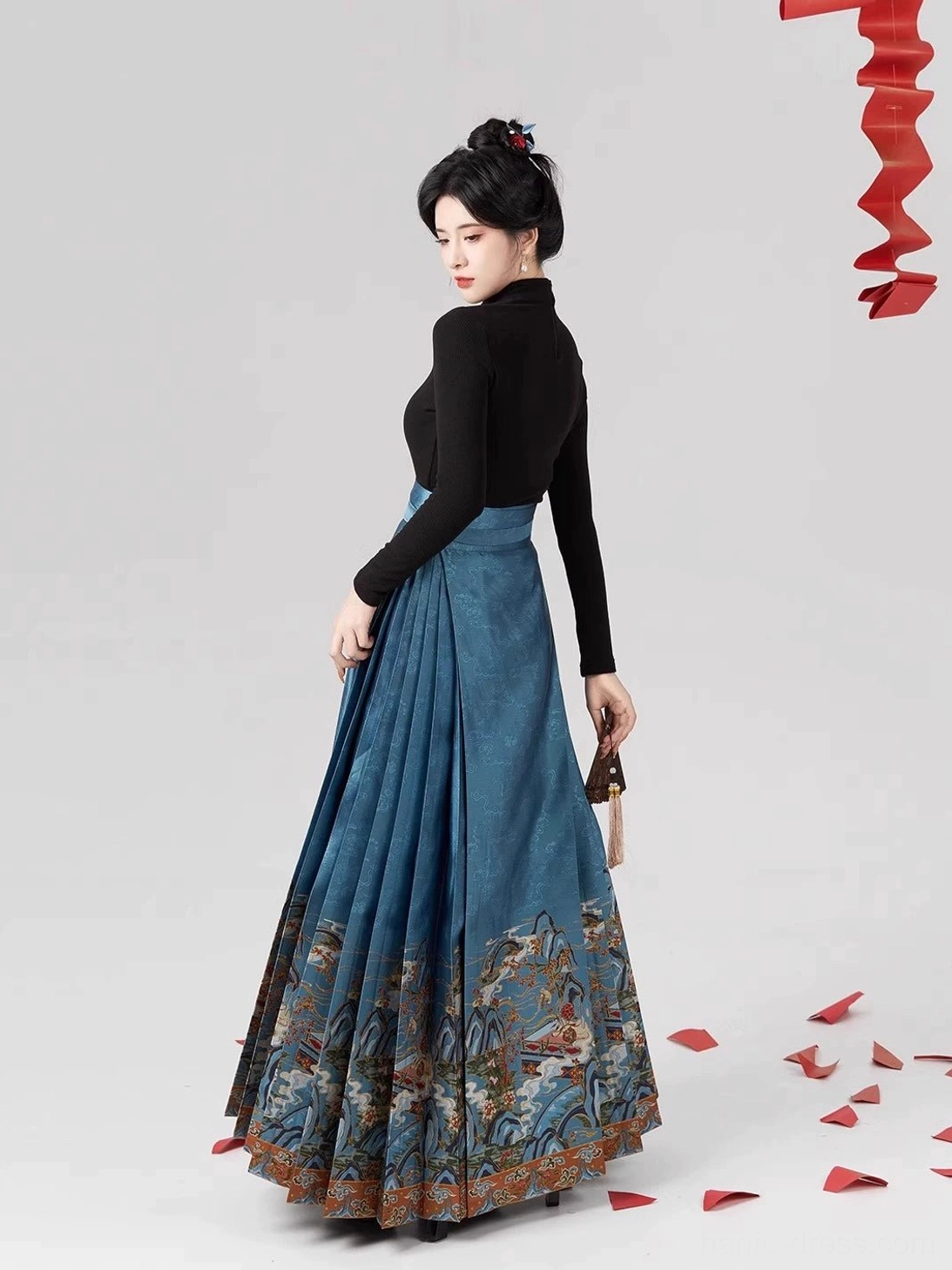 Back three-quarter view of dusty blue Ming Dynasty style mamianqun horse-face skirt with flowing pleats and detailed landscape bird hem pattern