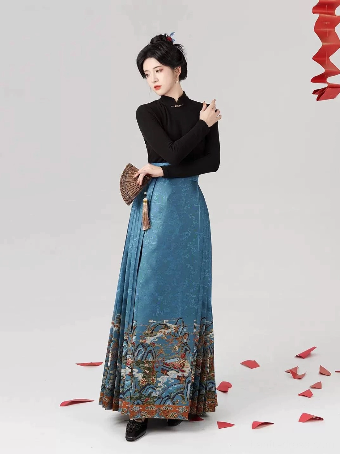 Front view of blue pleated mamianqun horse-face skirt styled with black turtleneck and folding fan for an elegant everyday Hanfu outfit