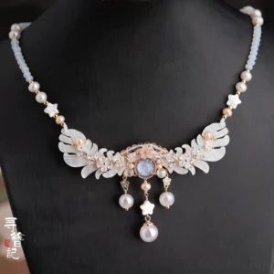 Chinese style Hanfu necklet worn on a black mannequin showing light blue beads, freshwater pearls, gold-toned petal ornaments, blue-gray center stone, and dangling pearl tassels