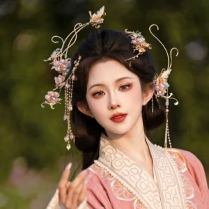 Female model wearing a pink embroidered Hanfu with the Falling Purple Smoke purple floral hair accessories set, showing gilded curved metal ornaments, gradient purple flowers, and long beaded tassels