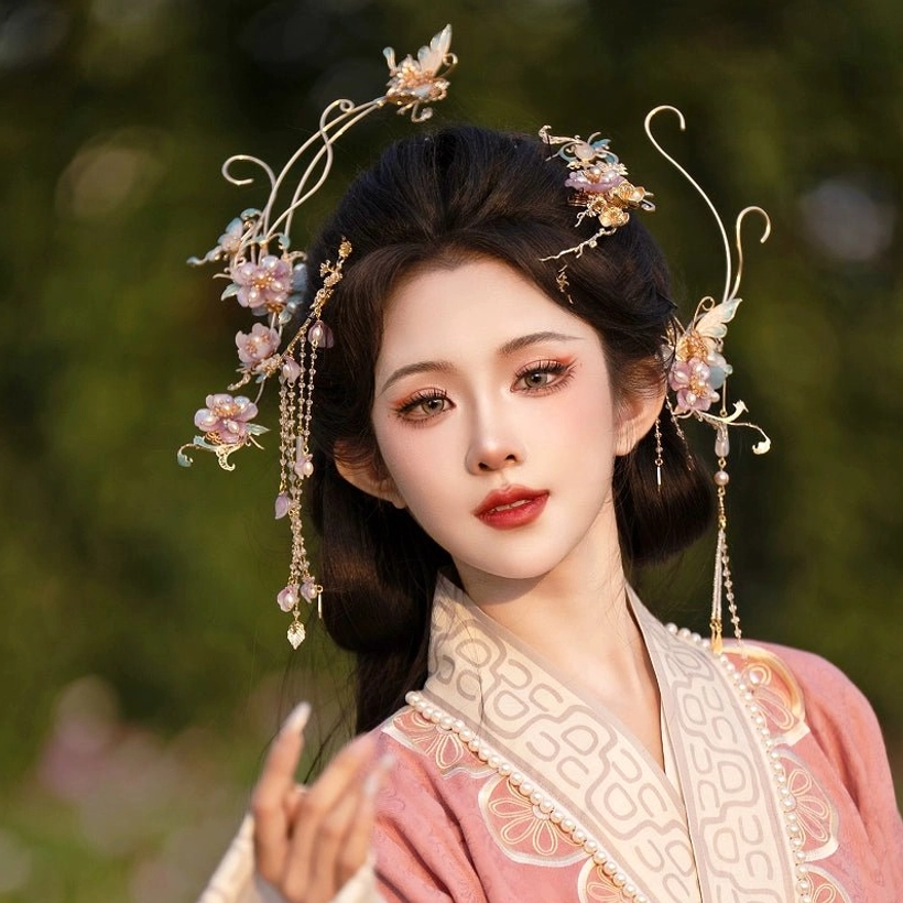 Female model wearing a pink embroidered Hanfu with the Falling Purple Smoke purple floral hair accessories set, showing gilded curved metal ornaments, gradient purple flowers, and long beaded tassels