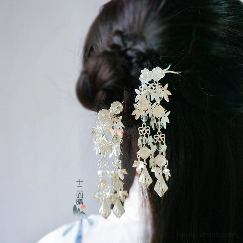 Silver traditional Chinese Hanfu hairpin with floral ornaments and long tassel pendants styled in a braided ancient hair bun
