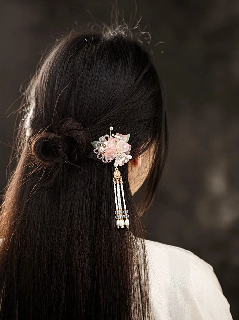 Side back view of Fanghua pink floral tassel hairpin worn with a traditional white hanfu hairstyle