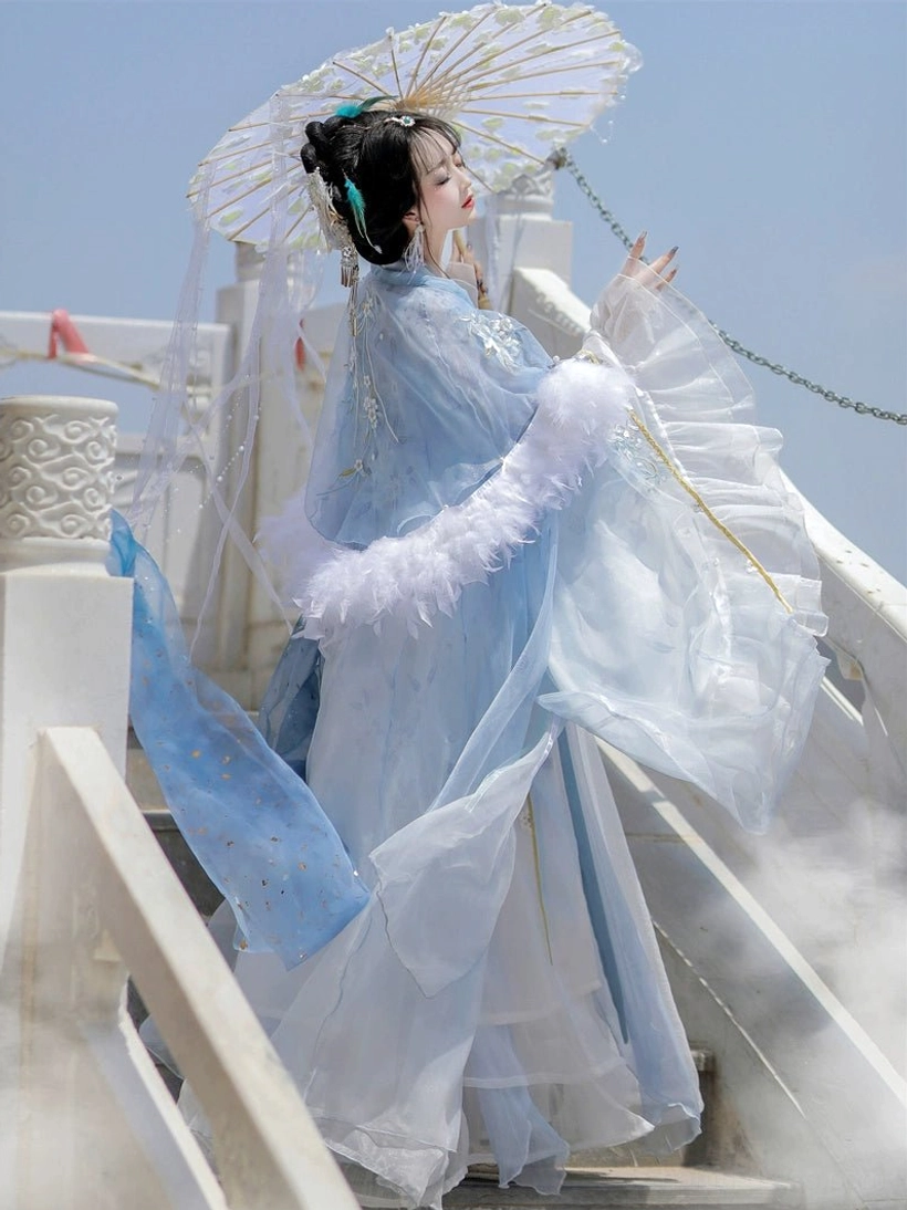 Side view of feather-trimmed blue gradient Hanfu cloak over Tang Dynasty Qixiong Ruqun dress with oiled paper umbrella