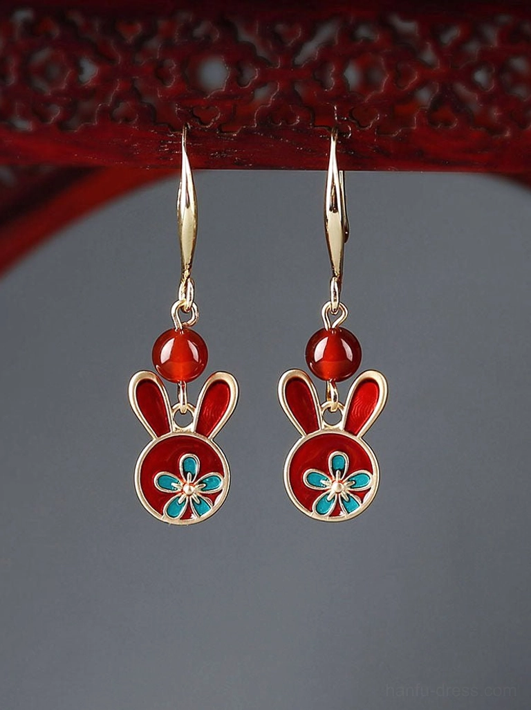 Front view of festive Chinese rabbit earrings with red enamel rabbit charms, red beads, gold-tone trim, and blue floral decoration