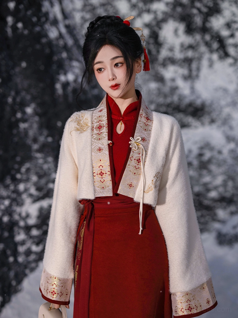 Front full-body view of an ivory festive Hanfu crop jacket styled with a traditional Chinese outfit on a model in a snowy outdoor setting