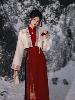 Side view of an ivory Hanfu crop jacket paired with a wine-red patterned mamian skirt and vintage handbag for a Chinese New Year outfit