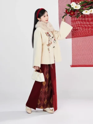 Festive modern Hanfu Chinese New Year outfit shown from the side with beige embroidered jacket, fluffy collar trim, deep maroon skirt, long dark hair, and coordinated seasonal styling