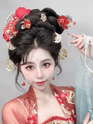 Woman wearing festive red blossom Hanfu hairpins and side ornaments in a traditional Chinese coiled hairstyle with red Hanfu costume