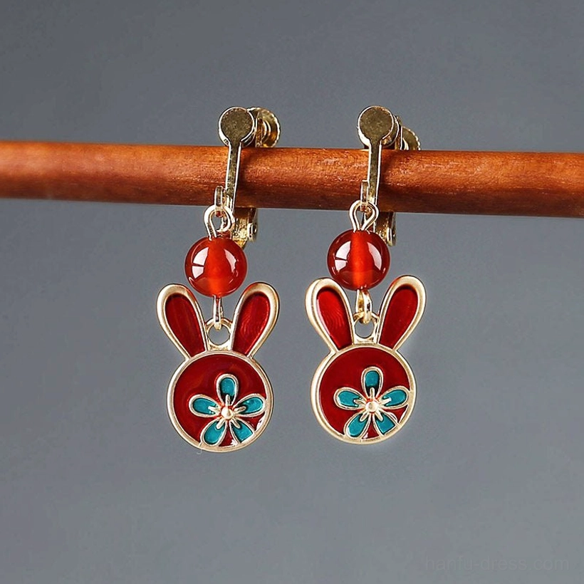 Festive red rabbit comfort clip-on earrings with gold-tone clips, red beads, blue floral enamel details, and rabbit charms