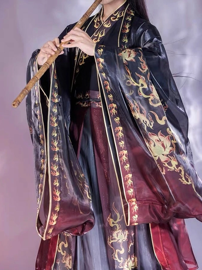 Fire Decree men hanfu three-quarter front view with flowing black wide sleeves gold flame motifs and bold red gradient skirt