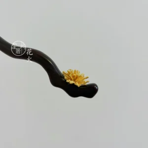 Fireworks Chinese hair stick with dark wavy wood shaft and golden burst ornament close-up