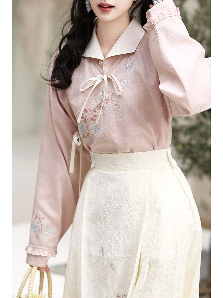 Close-up of dusty pink Ming-inspired hanfu shirt showing bow closures floral embroidery gathered cuffs and mamian skirt