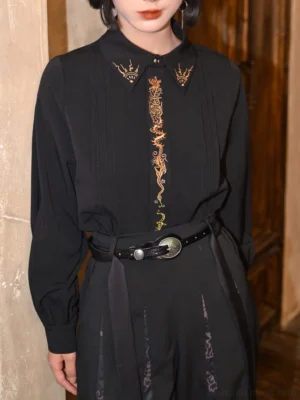 Close-up of black modern Hanfu shirt featuring ornate gold dragon embroidery on Chinese-style collar and front placket with lantern long sleeves