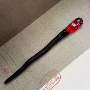 Flame Scepter Chinese hair stick with curved dark wooden shaft and faceted translucent ruby red crown on vintage Chinese paper background