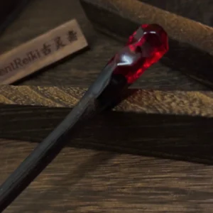 Close-up side view of Flame Scepter Hanfu hair stick showing dark wood grain and deep red faceted decorative topper