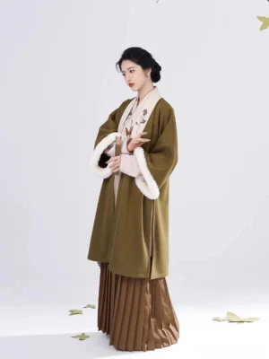 Modern Song Dynasty Hanfu outfit with olive green outer jacket, winged sleeves, white cuffs, and brown pleated skirt styled in a minimalist studio