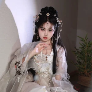 Woman wearing a layered traditional Chinese Hanfu necklace with freshwater pearls, colorful decorative charms, and tassels over an elegant beige Hanfu outfit