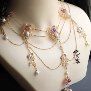Close-up of a layered Hanfu Chinese necklace with gold-tone chains, freshwater pearls, colorful gemstone-style accents, floral and leaf charms, and flowing tassel pendants displayed on a jewelry mannequin