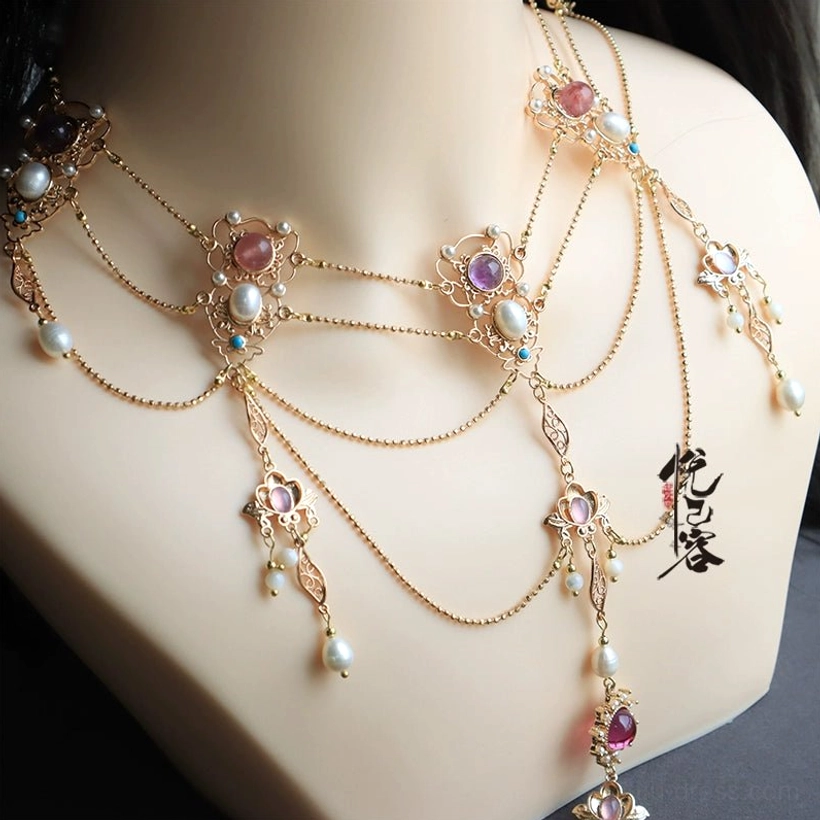 Close-up of a layered Hanfu Chinese necklace with gold-tone chains, freshwater pearls, colorful gemstone-style accents, floral and leaf charms, and flowing tassel pendants displayed on a jewelry mannequin