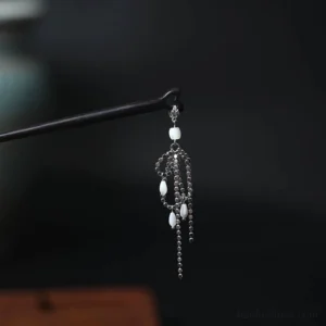Floating River Chinese hair stick with black wooden shaft silver-tone tassel chains and white beads shown in a left-side close-up
