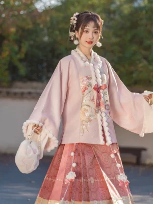 Front three-quarter view of a Ming Dynasty-inspired Hanfu set with floral embroidered pink square-collar top, wide pipa sleeves, fluffy cuffs, and red horse-face skirt