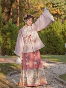 Flower Banquet Ming Dynasty Hanfu complete set with pale pink pipa-sleeve top, fluffy white trim, floral embroidery, and brick-red mamianqun skirt in a green outdoor garden