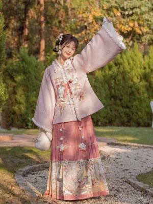 Flower Banquet Ming Dynasty Hanfu complete set with pale pink pipa-sleeve top, fluffy white trim, floral embroidery, and brick-red mamianqun skirt in a green outdoor garden