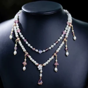 Front view of flower fairy double layer Chinese necklace on black jewelry mannequin with central white flower ornament, pearls, crystal drops and teardrop pendant