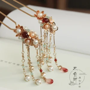 Flower Festival Chinese hair stick with warm gold-tone floral ornament faux pearls burgundy beads red teardrop pendant and delicate tassels displayed on a vintage book