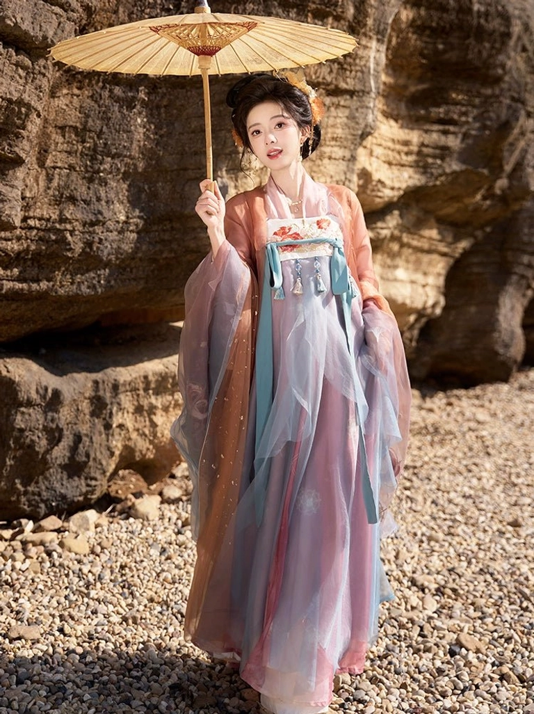Three-quarter view of a model wearing pink blue Tang Dynasty Hanfu with wide sleeves, floral hair ornaments, and an elegant oil paper umbrella