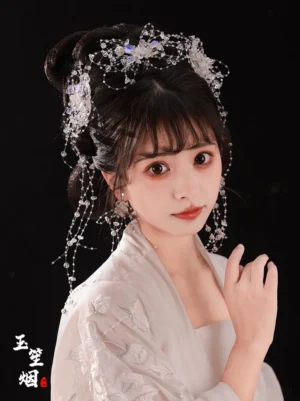 Model wearing a Flower Tears Hanfu hair accessories set with a sparkling beaded headdress, long crystal-style tassels, matching earrings, and white embroidered traditional Chinese clothing