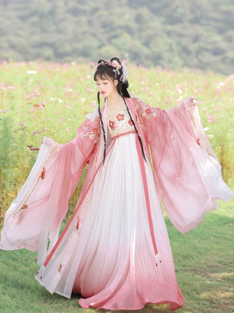 Flowing Flying Flower Tang Dynasty Hanfu Heziqun dress in motion with ombre pink skirt, embroidered robe, wide sleeves, and tassel sash