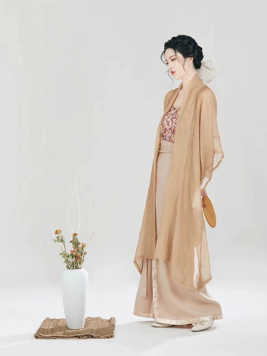 Full-body side view of the Fog Flower Hanfu outfit with flowing tan Changgan Temple beizi, spiral wrap skirt, white hair ribbon, and traditional wooden fan
