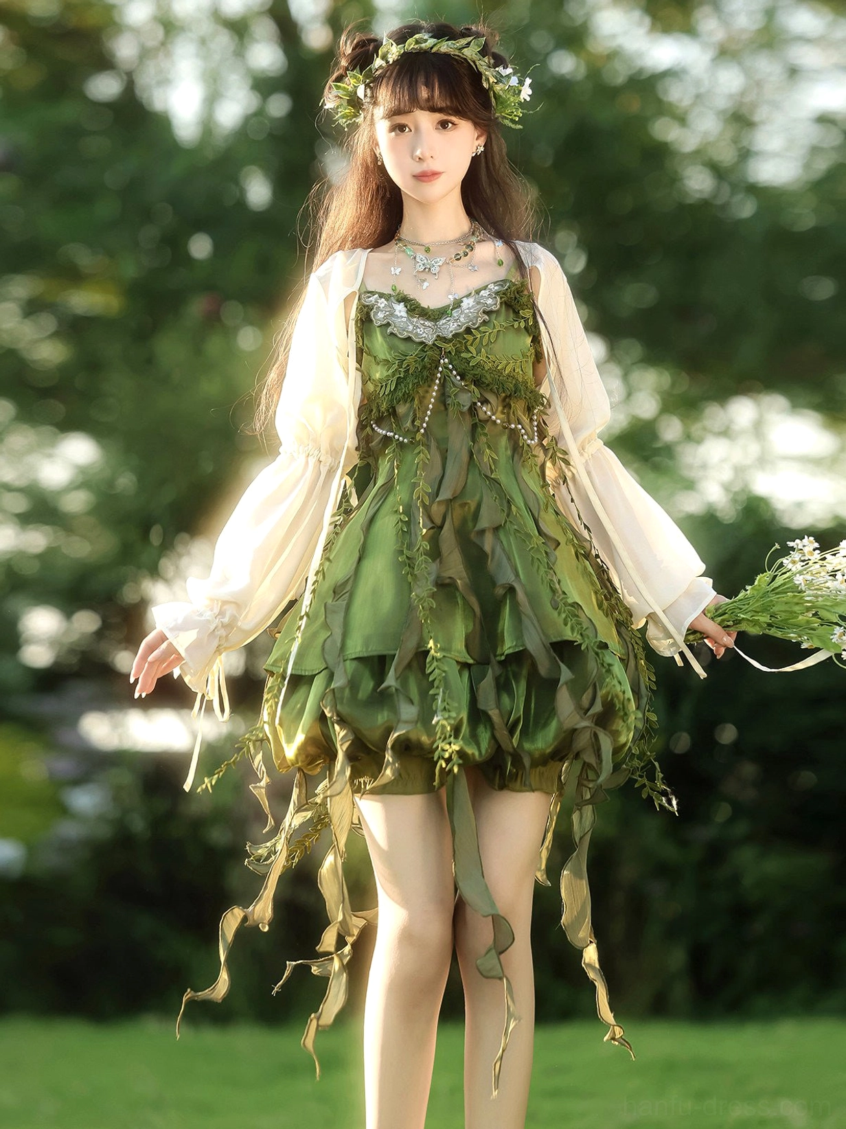 Full length forest green satin-look fairy dress with layered ruffles and long leaf tassels styled for a woodland summer photoshoot