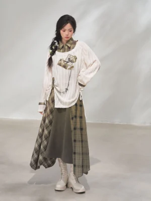 Front view of a women’s Forest Time Sand modern Hanfu xianxia outfit with off-white embroidered knit top and asymmetric green plaid skirt