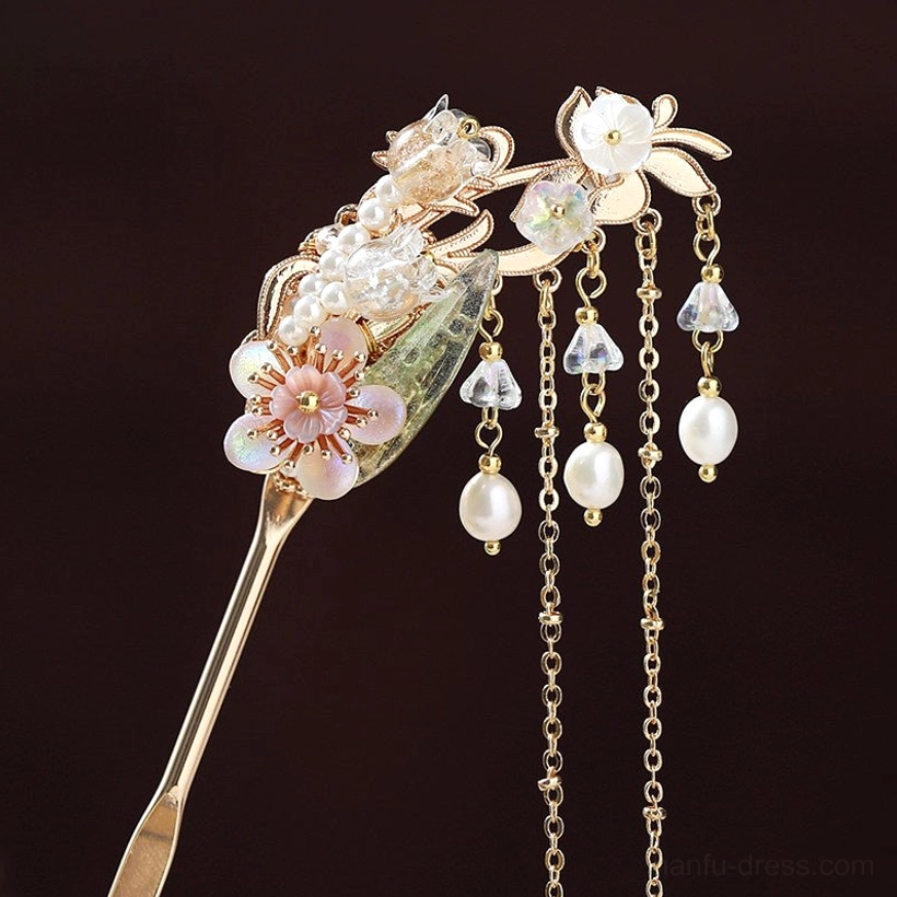 Front close-up of a Chinese Hanfu hair stick with white and pink flowers, glazed leaves, varied pearl ornaments, crystal pendants, and hanging tassels
