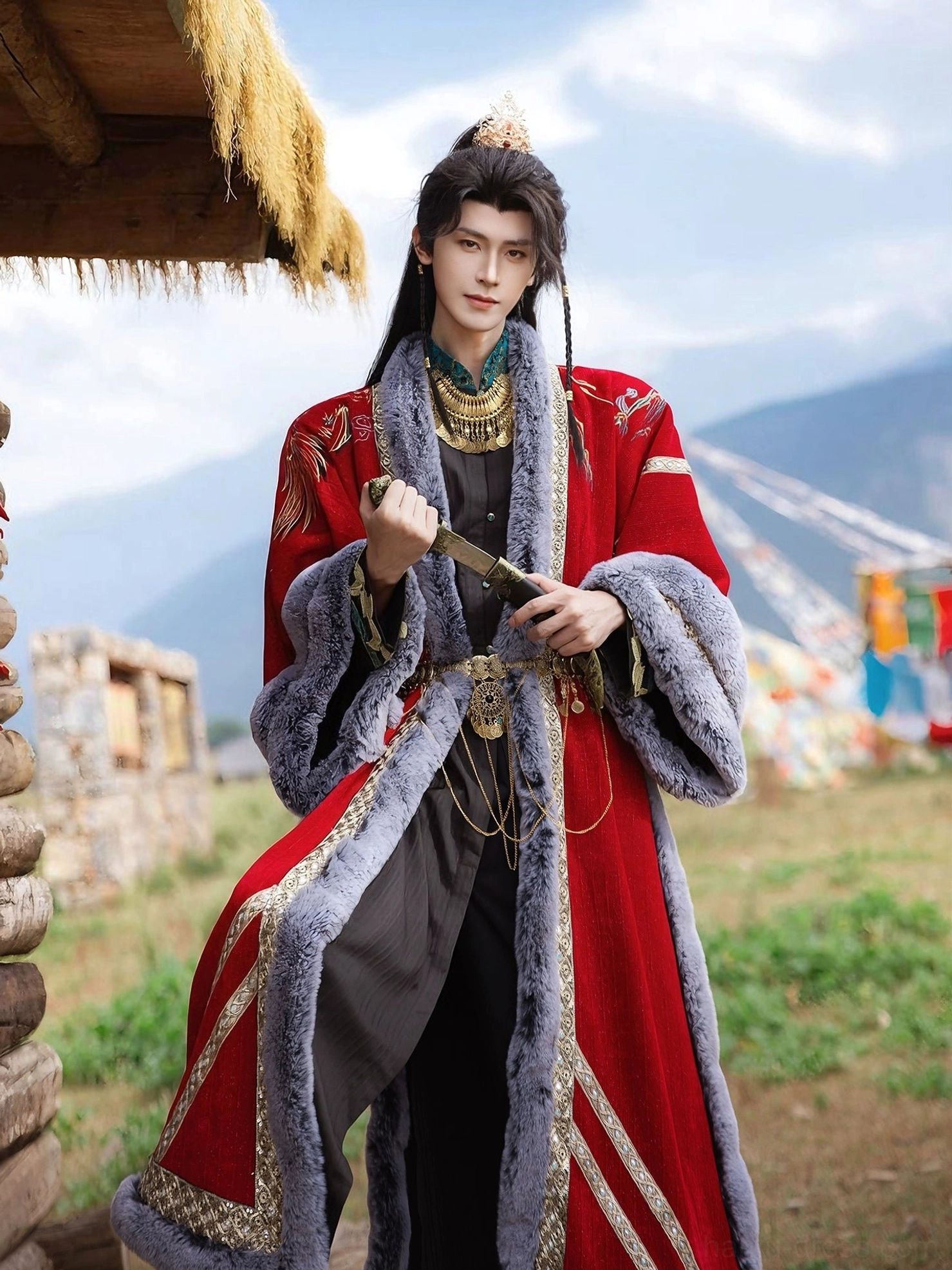 Front view of a complete red Song Dynasty inspired hanfu outfit with gold embroidery, neck ornaments, and decorative sword near a mountain hut