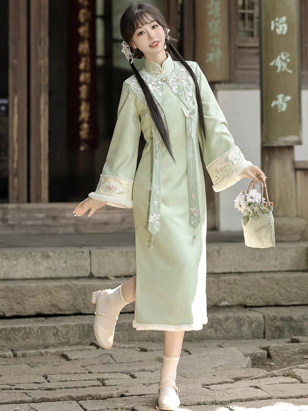 Side view of light green modern Hanfu cheongsam dress showing side hem slit, front tassels, and soft plush-look trim