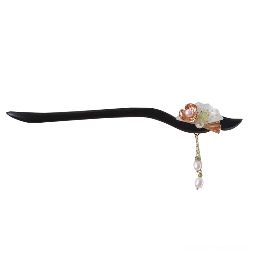 Full flat lay view of an ebony-toned Chinese hair stick with curved wooden shaft, flower ornament, green beads, and long pearl tassel